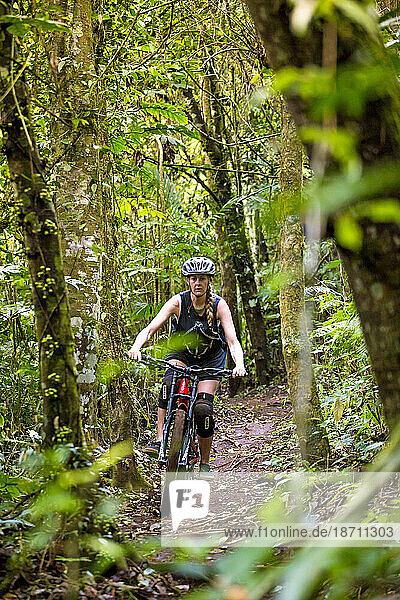Female Mountain Biker Riding In Forest Trail Of Bali  Indonesia