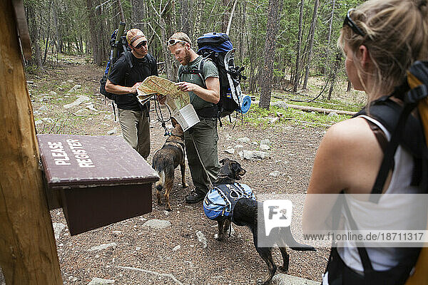 Hikers study their map at a trailhead register along the trail up Baker Gulch in the Never Summer Wilderness  Colorado.