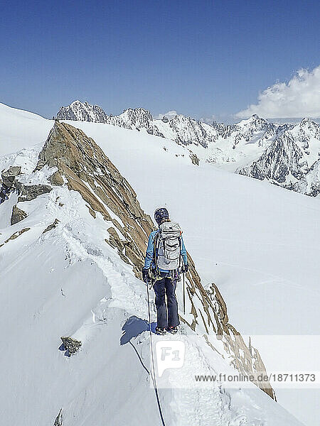 A woman mountaineer on an exposed snowy ridge in Chamonix