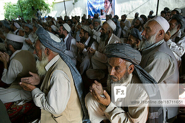 Elder Pashtun leaders cup their hands in prayer at a meeting where they pledged their support for a Tajik presidential candidate  in Kabul.