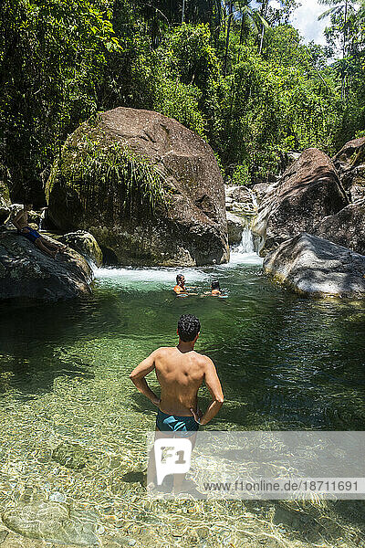 People enjoying beautiful green rainforest river with clear water