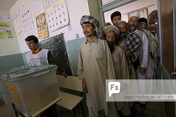 Afghan men wait in line to vote next to sealed ballot boxes at Wazir Akbar Khan school on the day of presidential and provincial elections in Mazar-i Sharif  Afghanistan on August