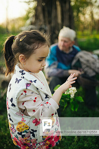 Child watching a ladybug with her great grandfather in background