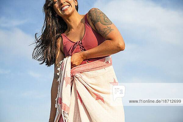 Latina woman having fun at the beach with towel wrap