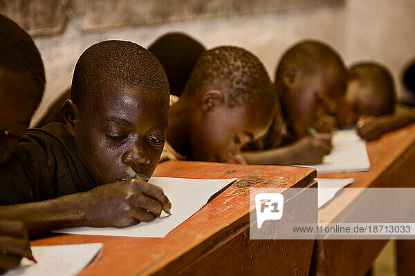 Boys work at their desks in a Rwandan school house.