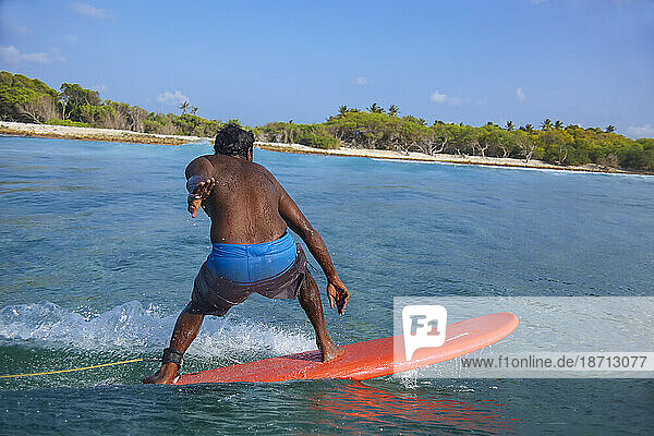 Shirtless man surfing near coastline  Male  Maldives