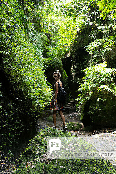 Traveler woman with a backpack in the jungle of Bali.