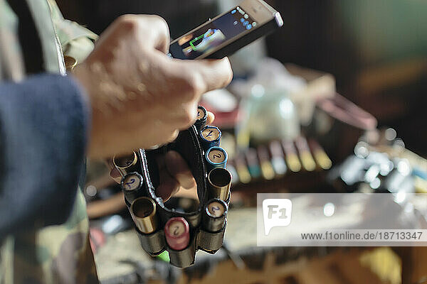Young man with smart phone and shotgun ammunition  Tikhvin  Saint Petersburg  Russia
