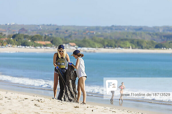 Women picking up trash at beach  Jimbaran  Bali  Indonesia