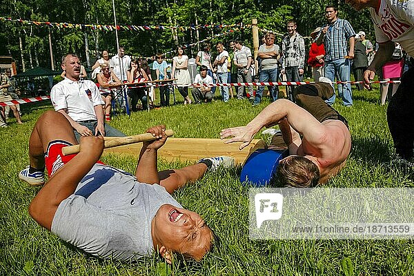 Men Performing Mas-wrestling Game On City Park With Traditional Stick