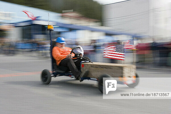 A man races his fancy soap box racer  4th of July celebrations  Cordova  Alaska.