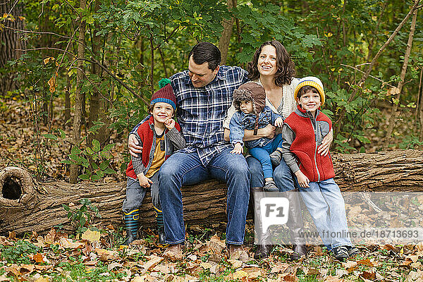portrait of a family sitting together in a wooded park