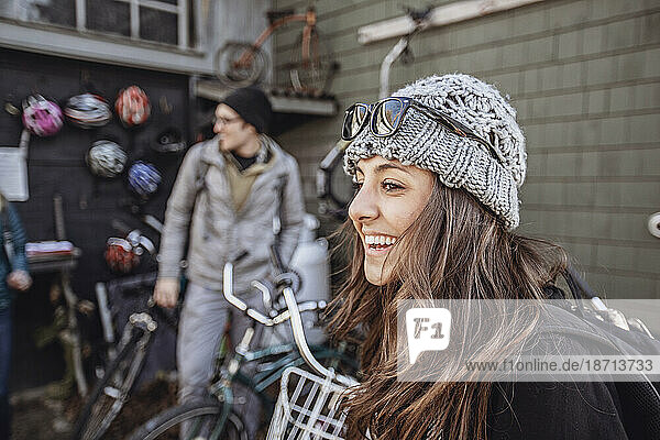 A young woman smiles while looking at bikes to rent in Maine