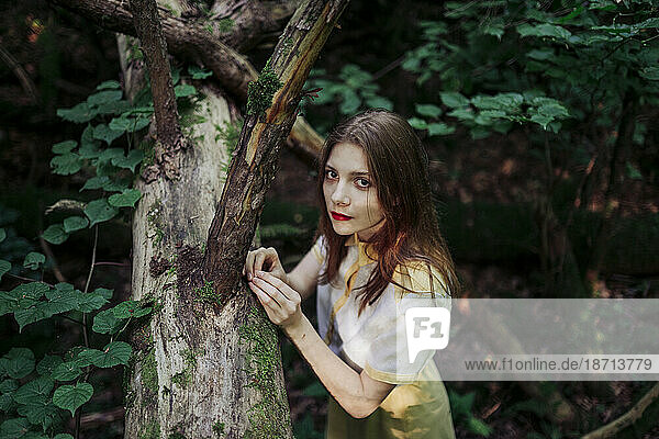 beautiful woman in the forest near the tree