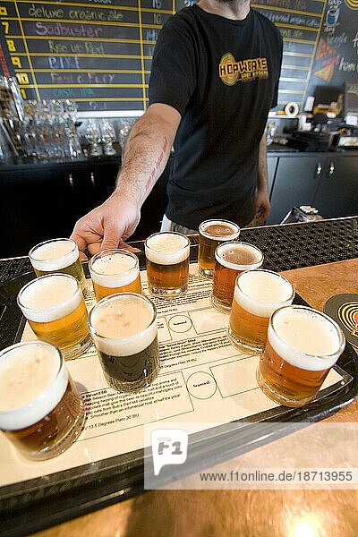 Man serves selection of craft beers.