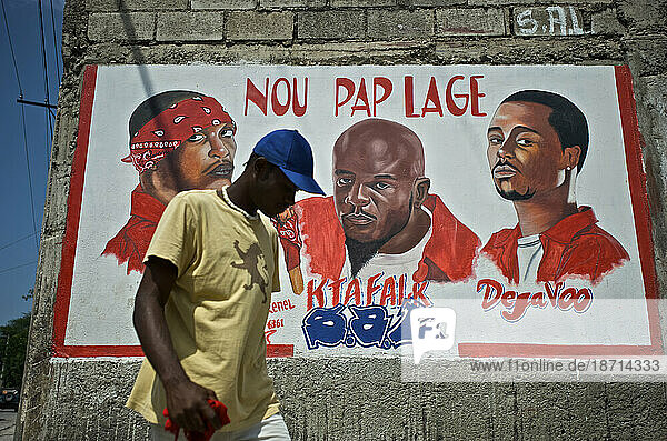 A man walks past a mural dedicated to the deceased members of the rap kreyol group Barikad Crew  in Port-au-Prince  Haiti.