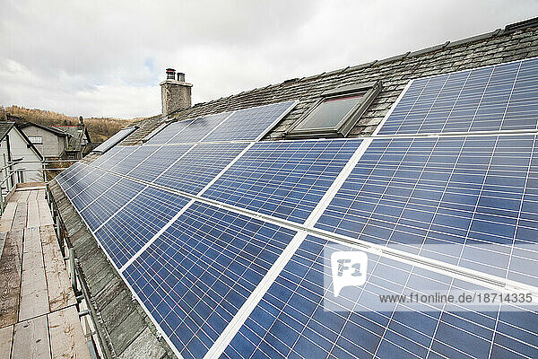 Solar voltaic electricity generating panels and solar hot water panels on a house roof in Ambleside  Cumbria  UK. This array provides all the hot water and the electricity for the