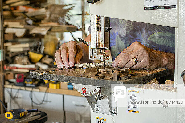 close-up view of a man doing work at a workbench in workshop