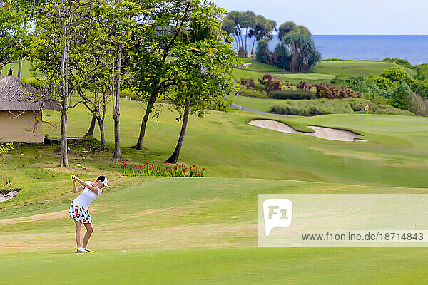 Young woman playing golf on sunny day