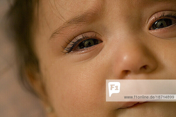 Close up view of a baby girl's sad expression.