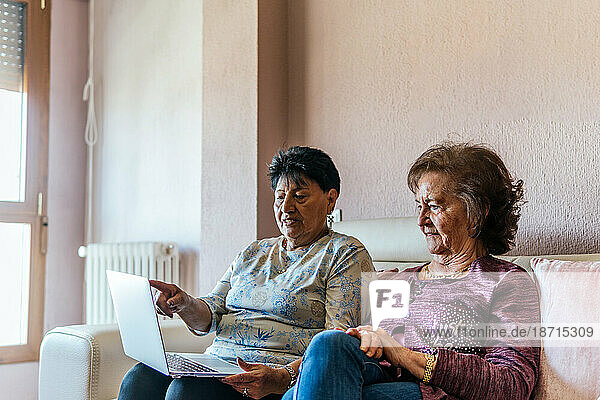 two elderly women watching a movie on the laptop