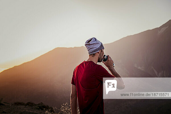 Hiker drinking water at sunset in Guajara mountain  El Teide