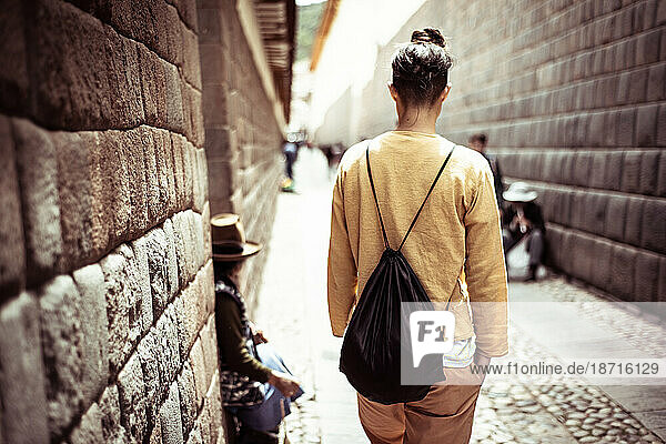 traveler walks down beautiful old stone cobble street in historical