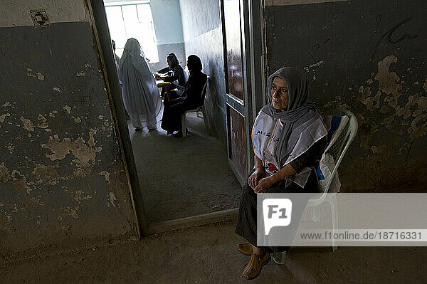 An Afghan poll worker sits by the door of a polling room on the morning of election day  in Mazar-i Sharif  Afghanistan at August 20  2009.