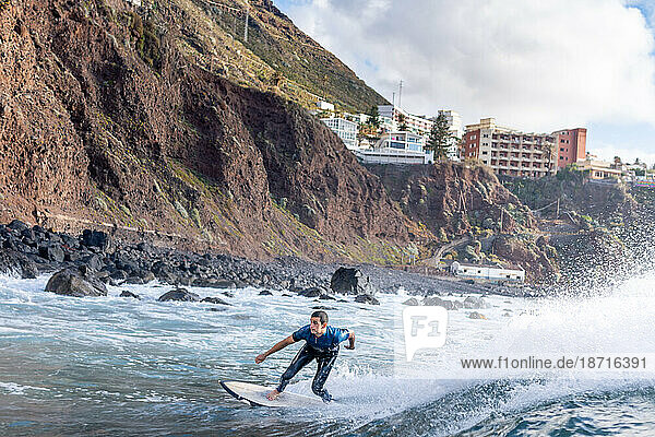 Surfer man catching a wave in Tenerife