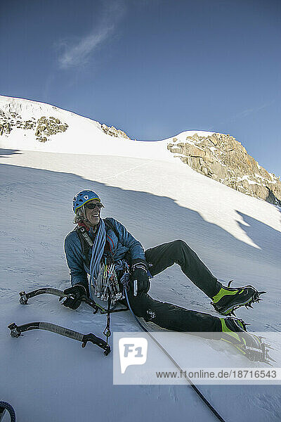 An alpinist in his 50s enjoys a break after completing a steep climb