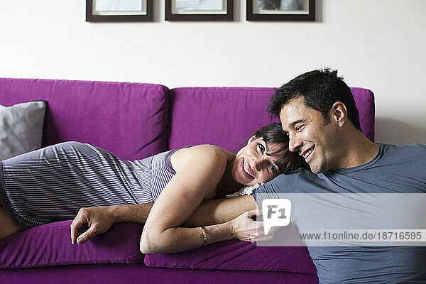 A man and woman relax on a sofa.