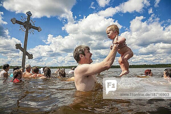 A Man Lifts His Child From Icy Lake Water In Lake Tikhvin  Russia