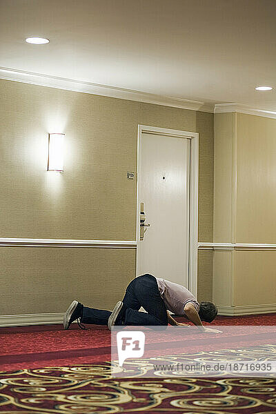 A man spies behind a hotel door in New Orleans.