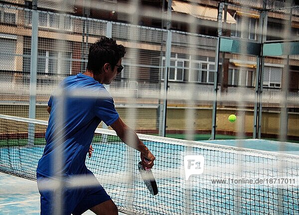 Man playing padel on the court.
