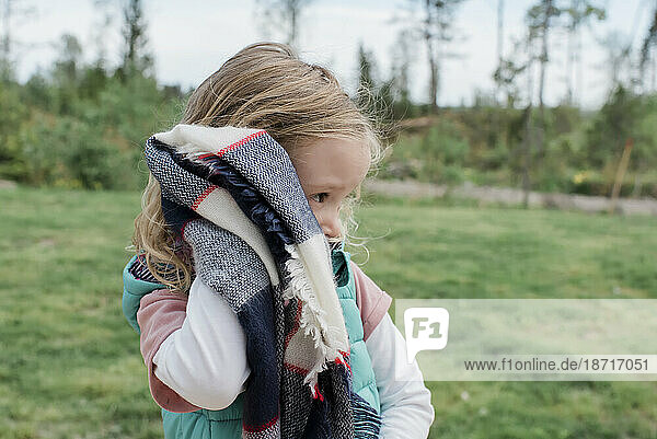 girl holding her scarf looking sad