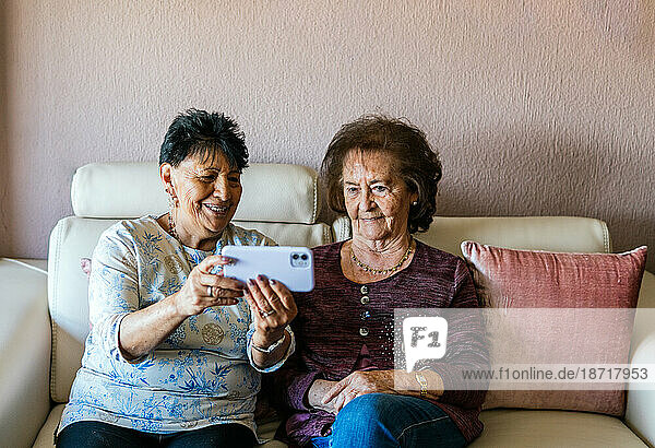 two old women taking a selfie with their smartphone