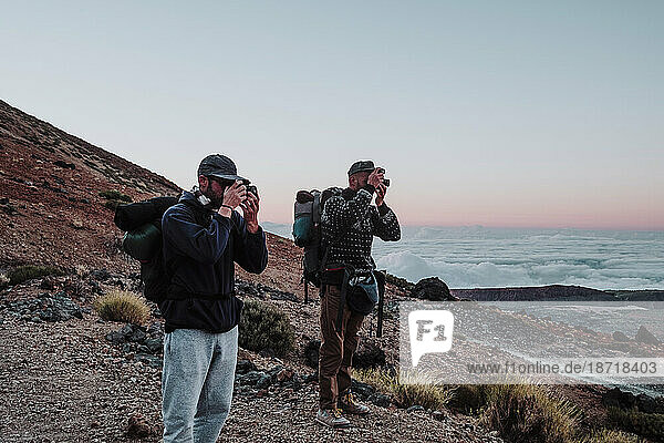 Hikers photographers taking photos in the volcano El Teide at sunset