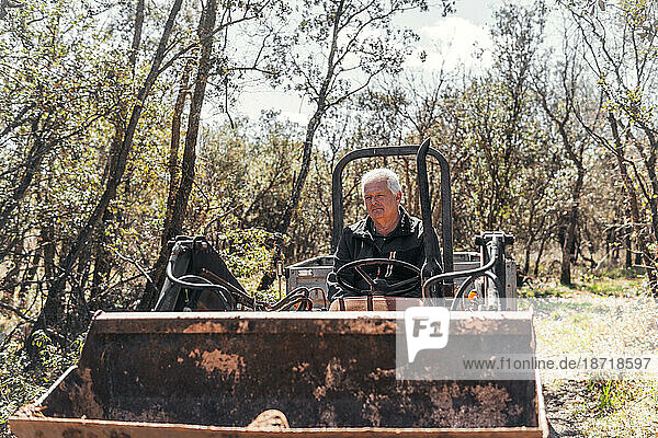 gray-haired man working with the tractor