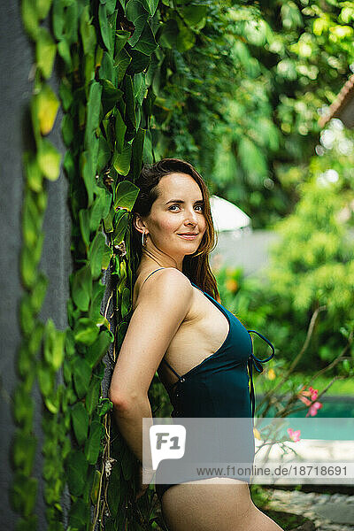 Brunette woman in a swimsuit in a tropical vibe. Bali