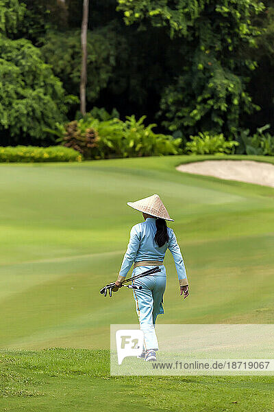 Rear view of woman walking on golf court