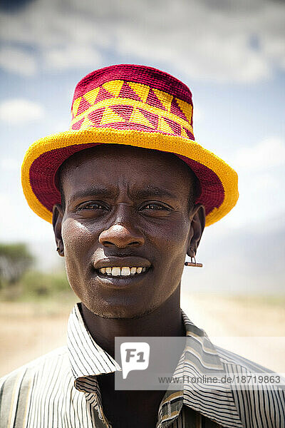 A portrait of a young man on a dusty road in the remote areas of the Omo Valley.