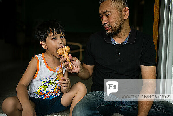 Boy and father eating ice cream