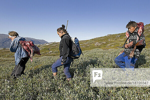 Foster parent and foster children bring caribou meat back to a summer camp near Nuuk  Greenland.