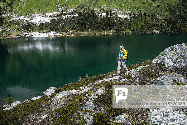 Full length view of women hiking by an alpine mountain lake in Canada.