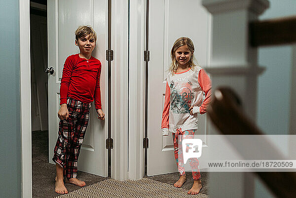 Girl and Boy in pajamas standing in doorway