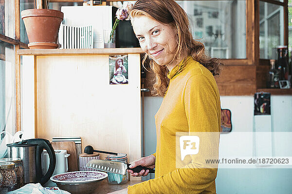 beautiful woman preparing food at home smiles in window light