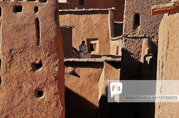 African man Talking on cellphone amongst clay buildings in Morocco