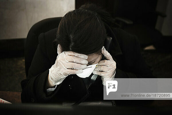 A receptionist at the phone wearing mask and plastic gloves during the swine flu epidemic in Mexico City  DF  Mexico.