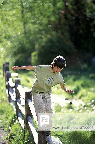 A young boy balances on a fence in Telluride  Colorado.