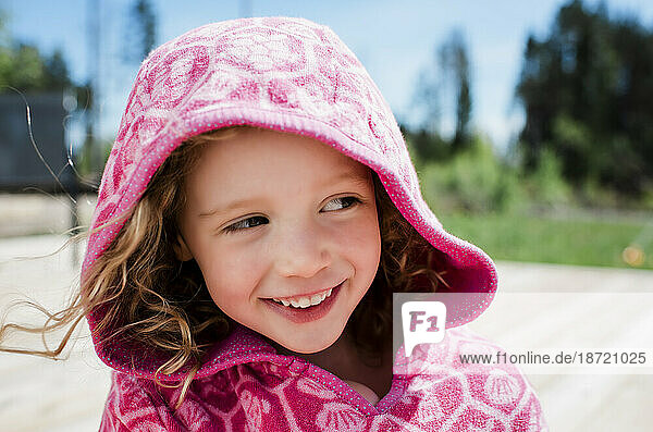 portrait of a girl smiling with her hood up in summer